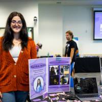 Elysia Azzi standing next to her booth